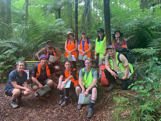 Group photo of some people in a forest wearing high vis
